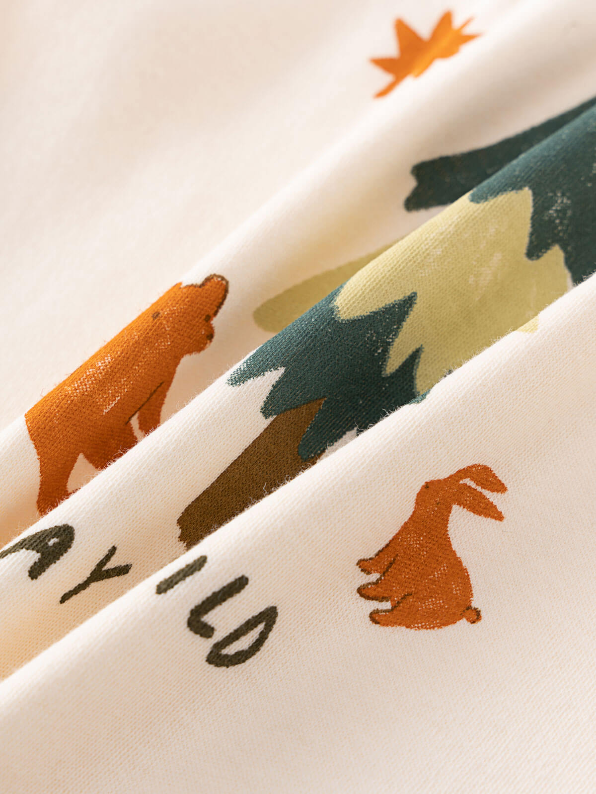 Close-up of fabric with bear, tree, and rabbit designs on a white background Baby Feature Print Long Sleeve Tee - Stay Wild Baby boy
