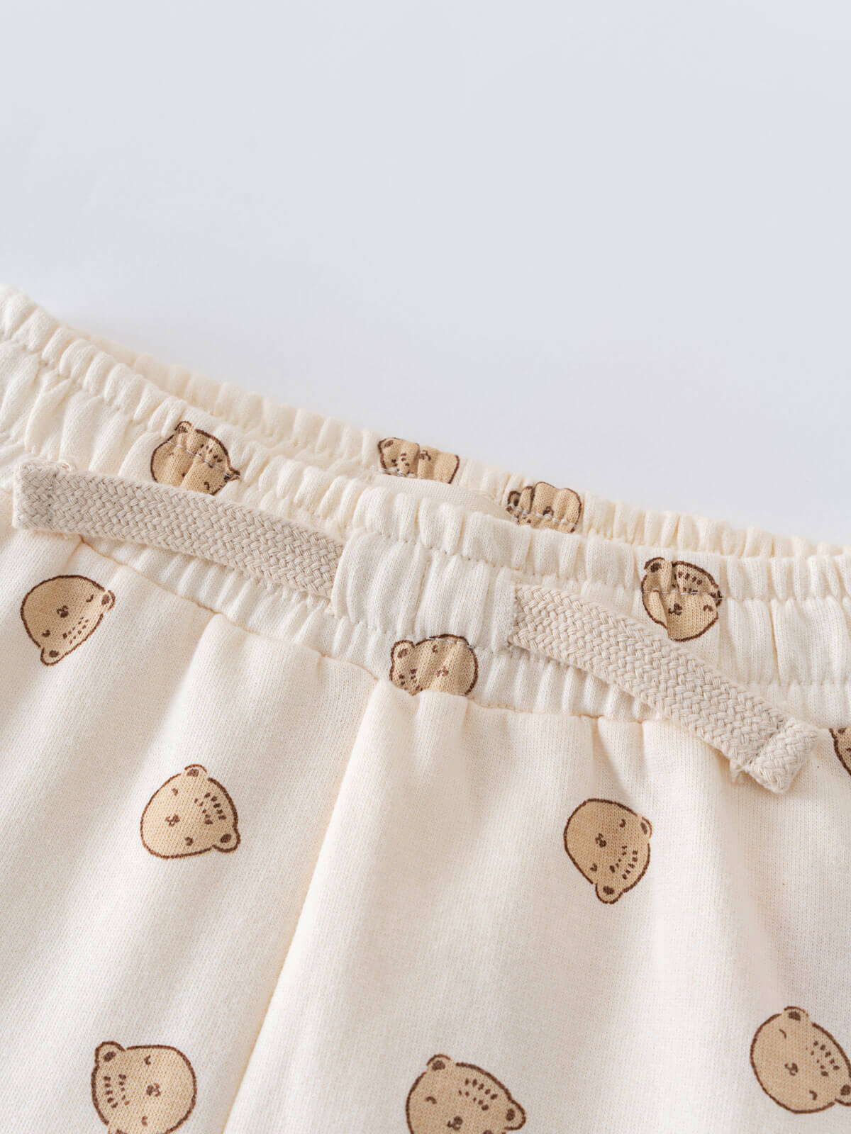 Close-up of cream-colored baby pants with small bear print pattern Printed Sweatpants - Cosy Bear Ecru Baby boy