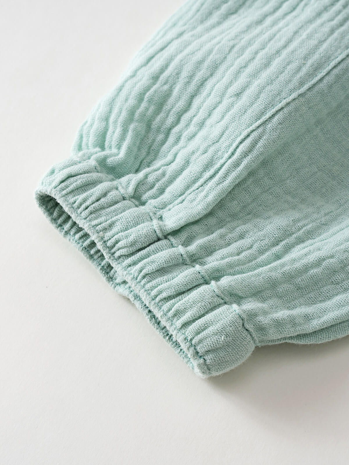 Close-up of mint green ribbed fabric with elastic gathered cuffs Baby Muslin Pants - Calla Green Baby boy