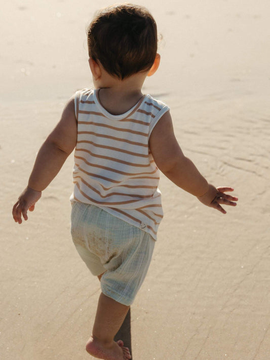 toddler boy walking on the sand wearing a striped sleeveless cotton tee