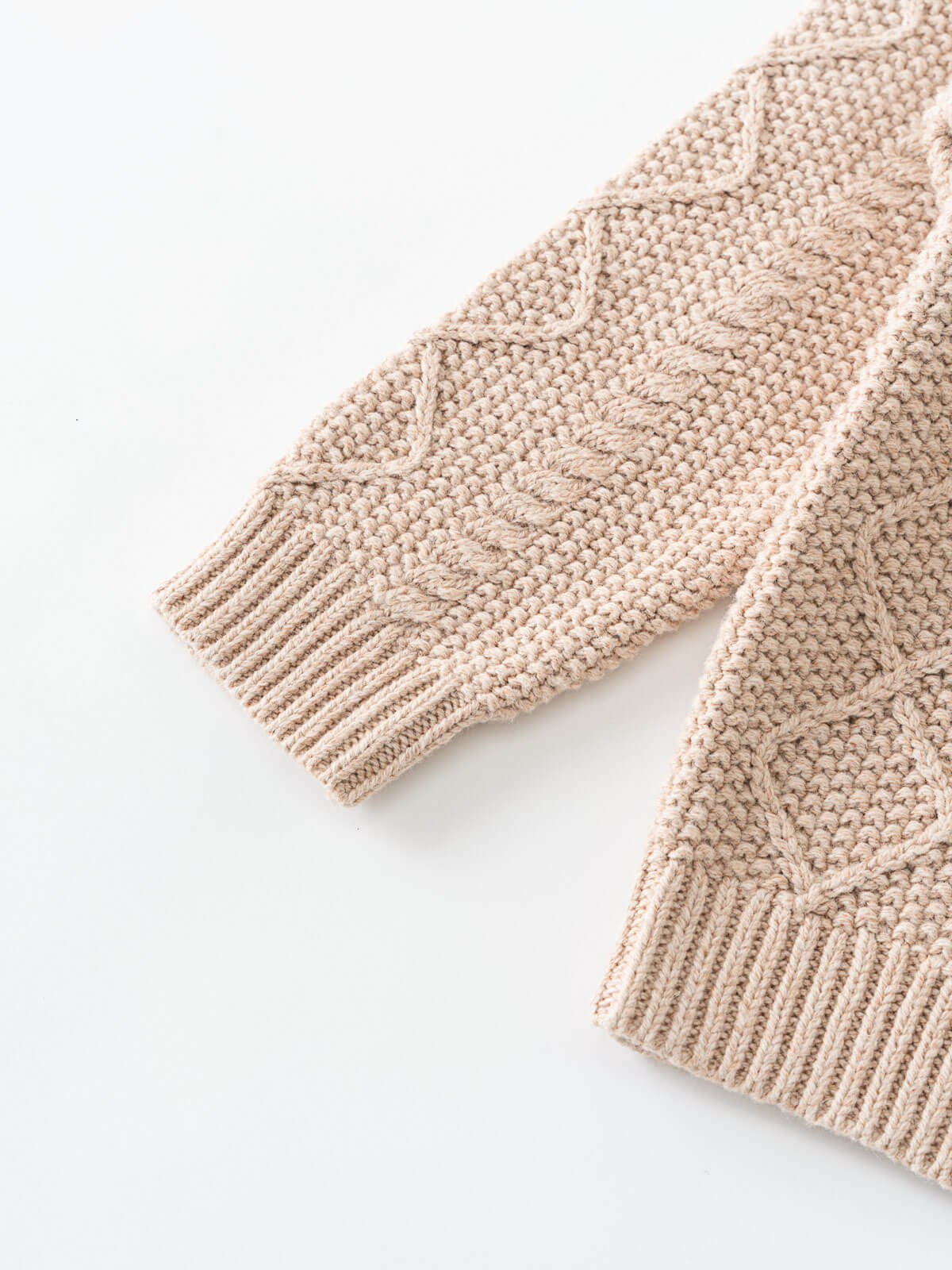 Close-up of a beige knitted sweater on a white background Cable Knit Jumper - Wicker Boys