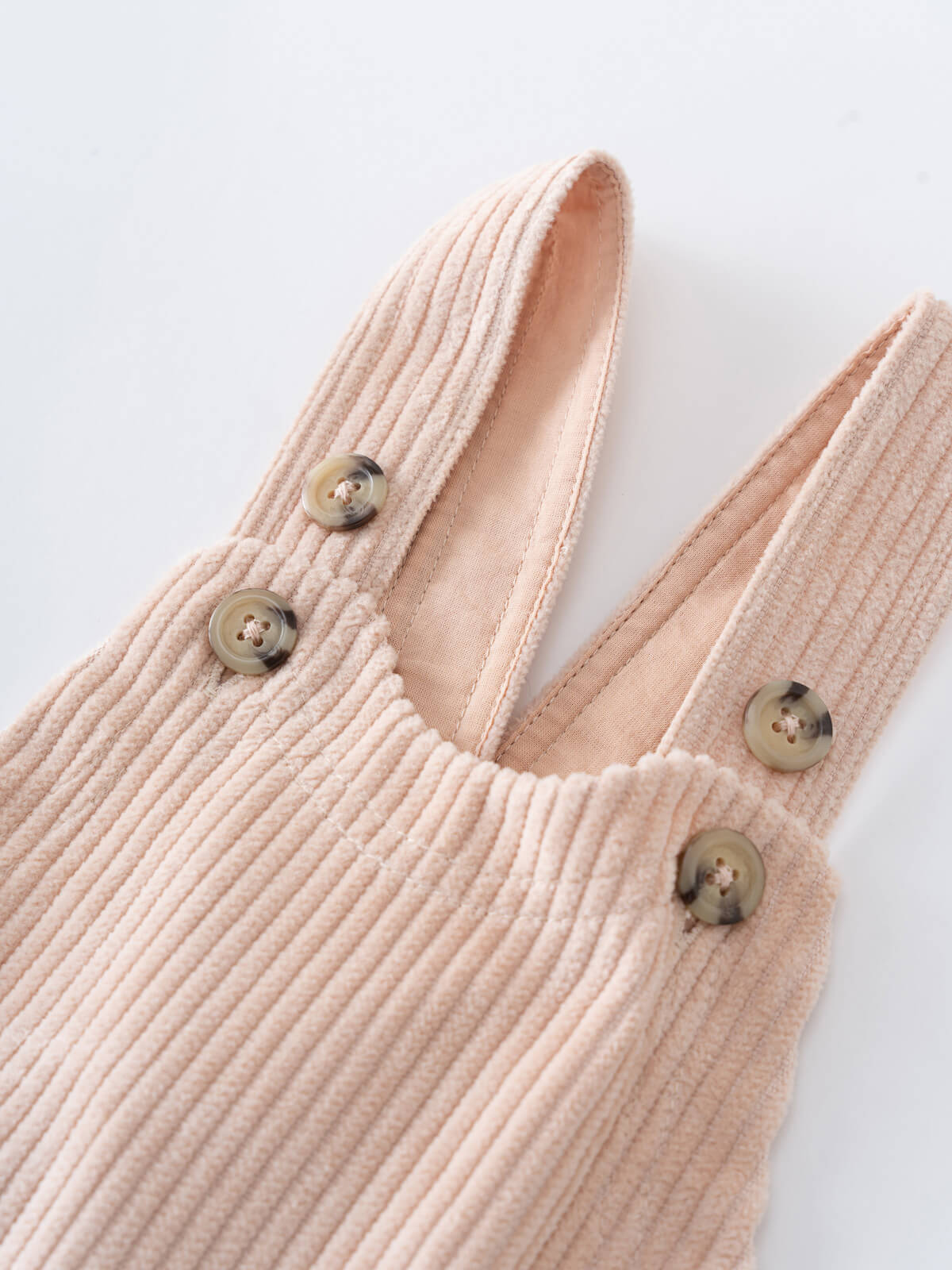 Close-up of a Beige corduroy overalls with button details on a light gray background Corduroy Overalls - Clay Baby boy