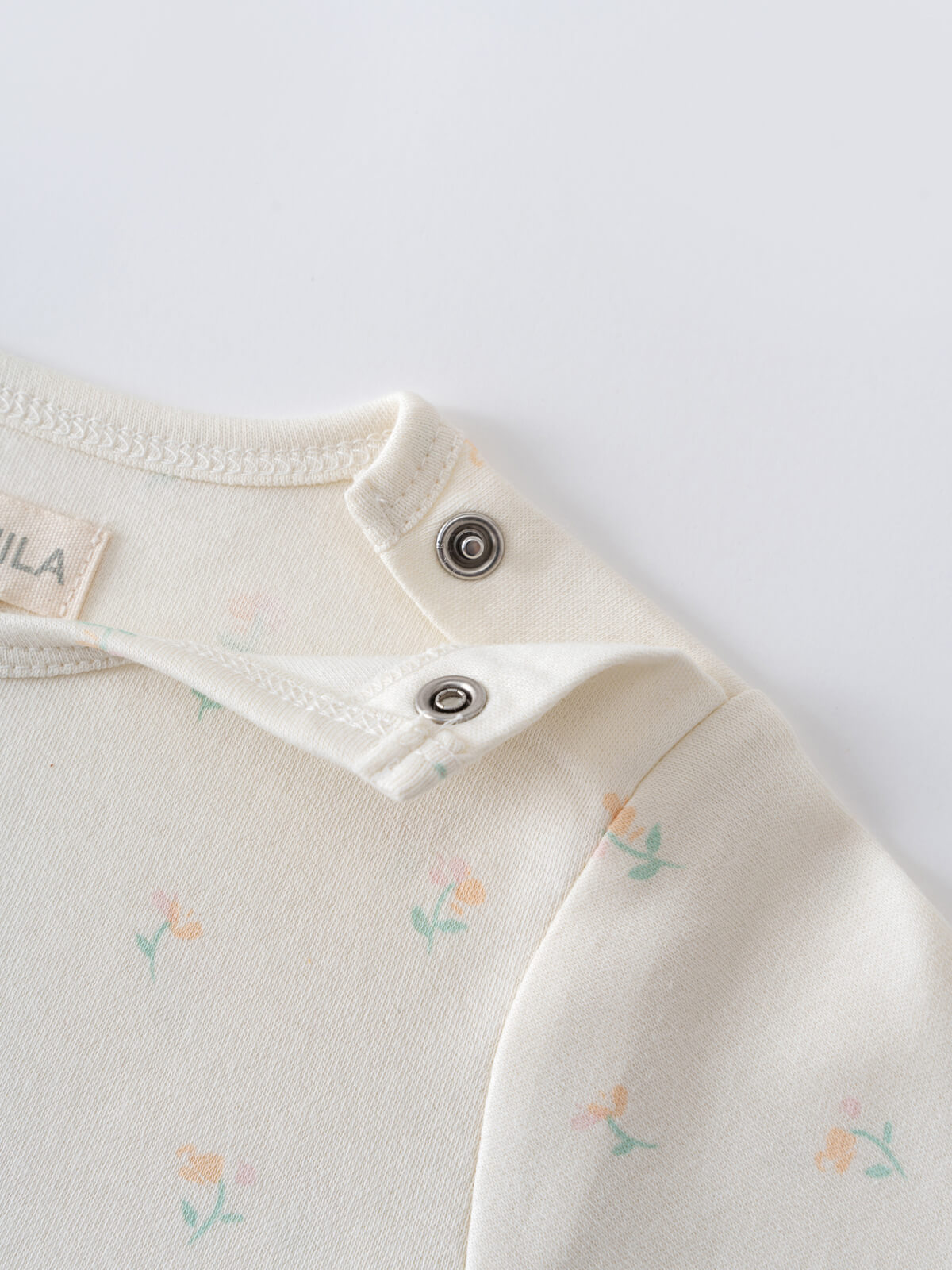 Close-up of cream colored baby bodysuit with floral print and metal snap buttons Ella Long Sleeve Bodysuit - Spring Bloom Baby girl