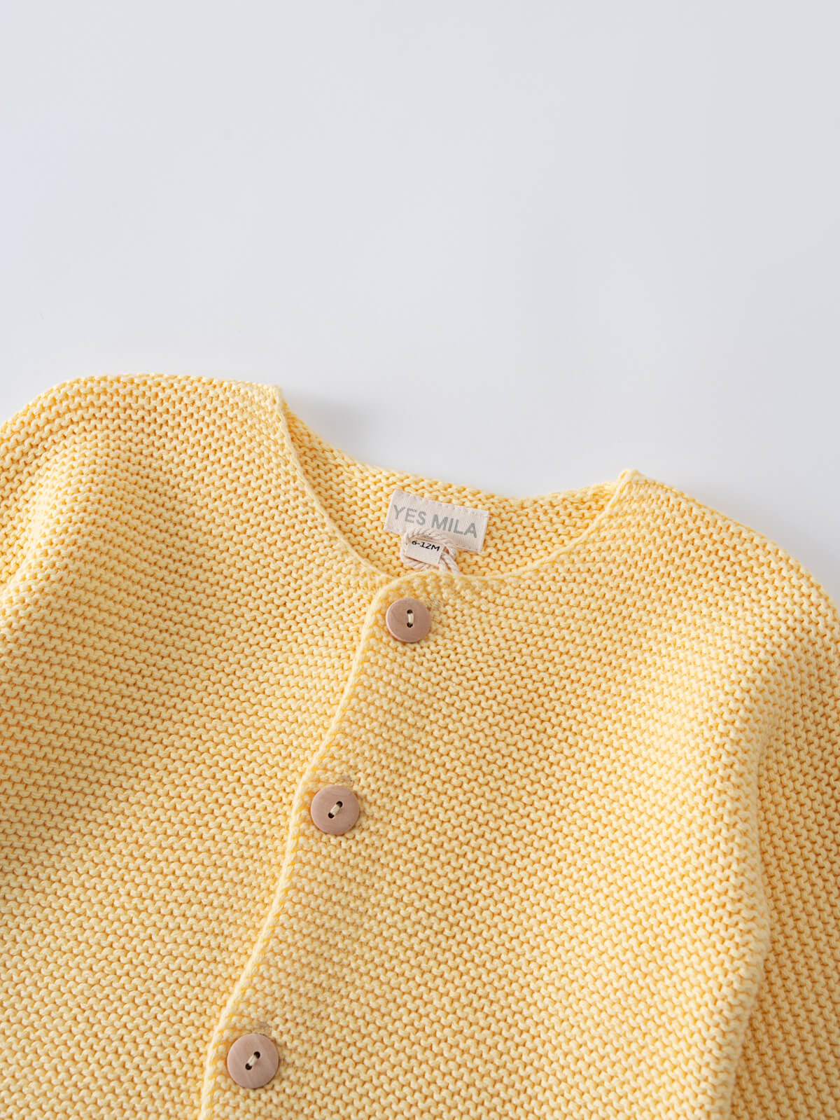 Close-up of a yellow knitted cardigan with wooden buttons Lily Cardigan - Sun Soaked Baby girl