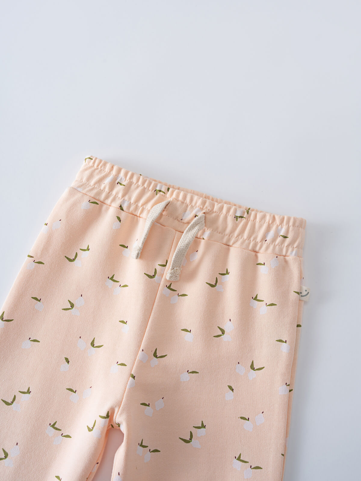 Close-up of peach sweatpants with white and green pattern, elastic waistband Nina Sweatpants - Citrus Baby girl