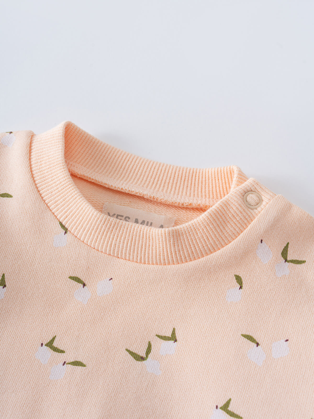 Close-up of a peach sweatshirt collar with floral print and button detail Nina Sweatshirt - Citrus Baby girl
