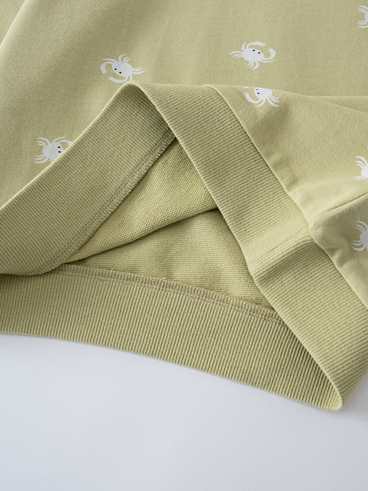 Folded sage green sweatshirt with white crab embroidery pattern throughout Remi Sweatshirt - Crabby Boys