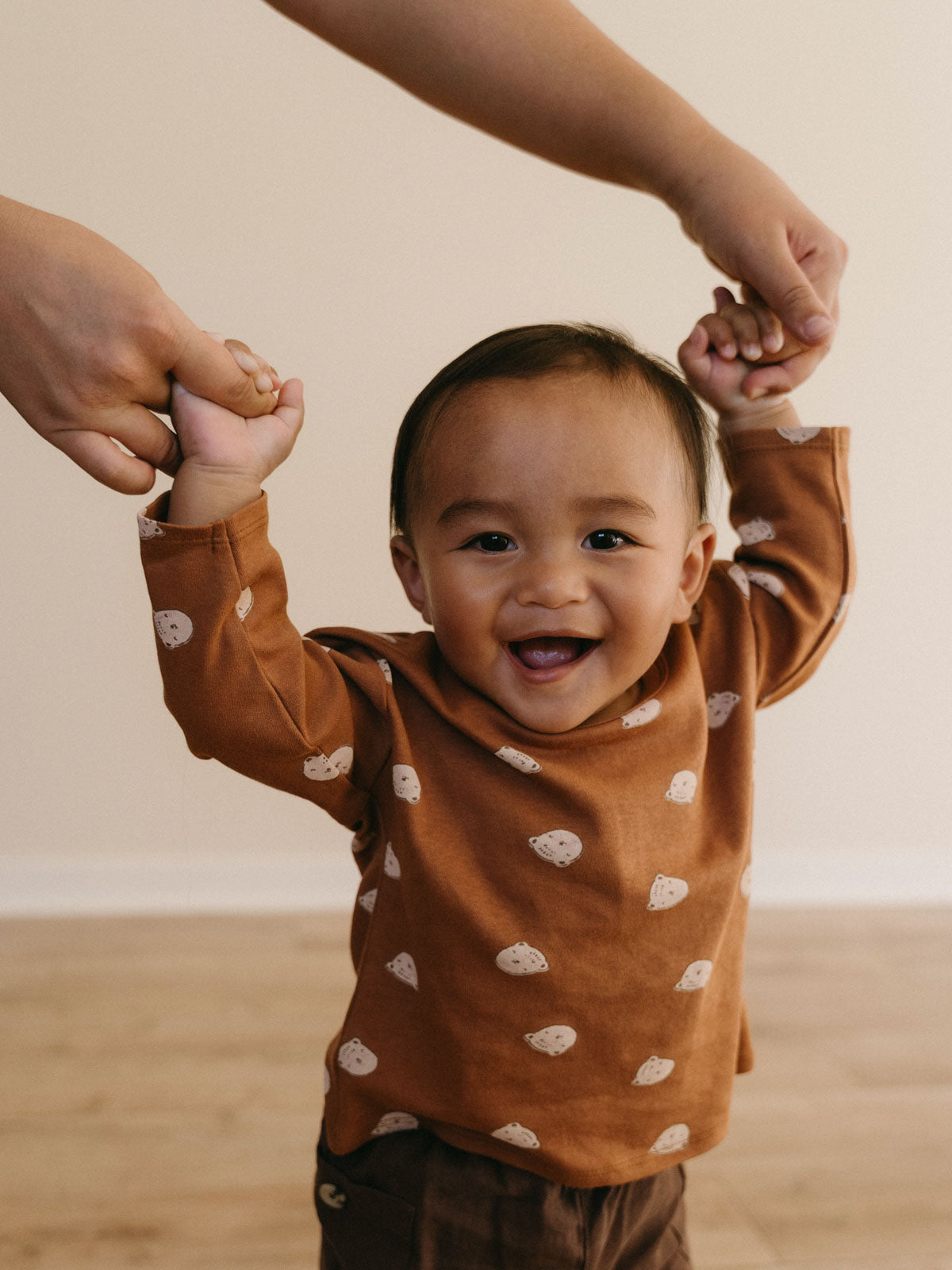 Smiling toddler wearing an orange long sleeve shirt with white bear print Baby Printed Long Sleeve Tee - Cosy Bear Russet Baby boy