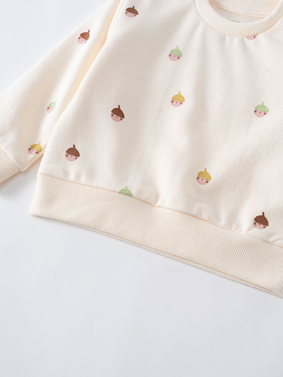 Close-up of cream sweatshirt with embroidered acorn faces pattern Baby Printed Sweatshirt - Little Acorn Ecru Baby girl