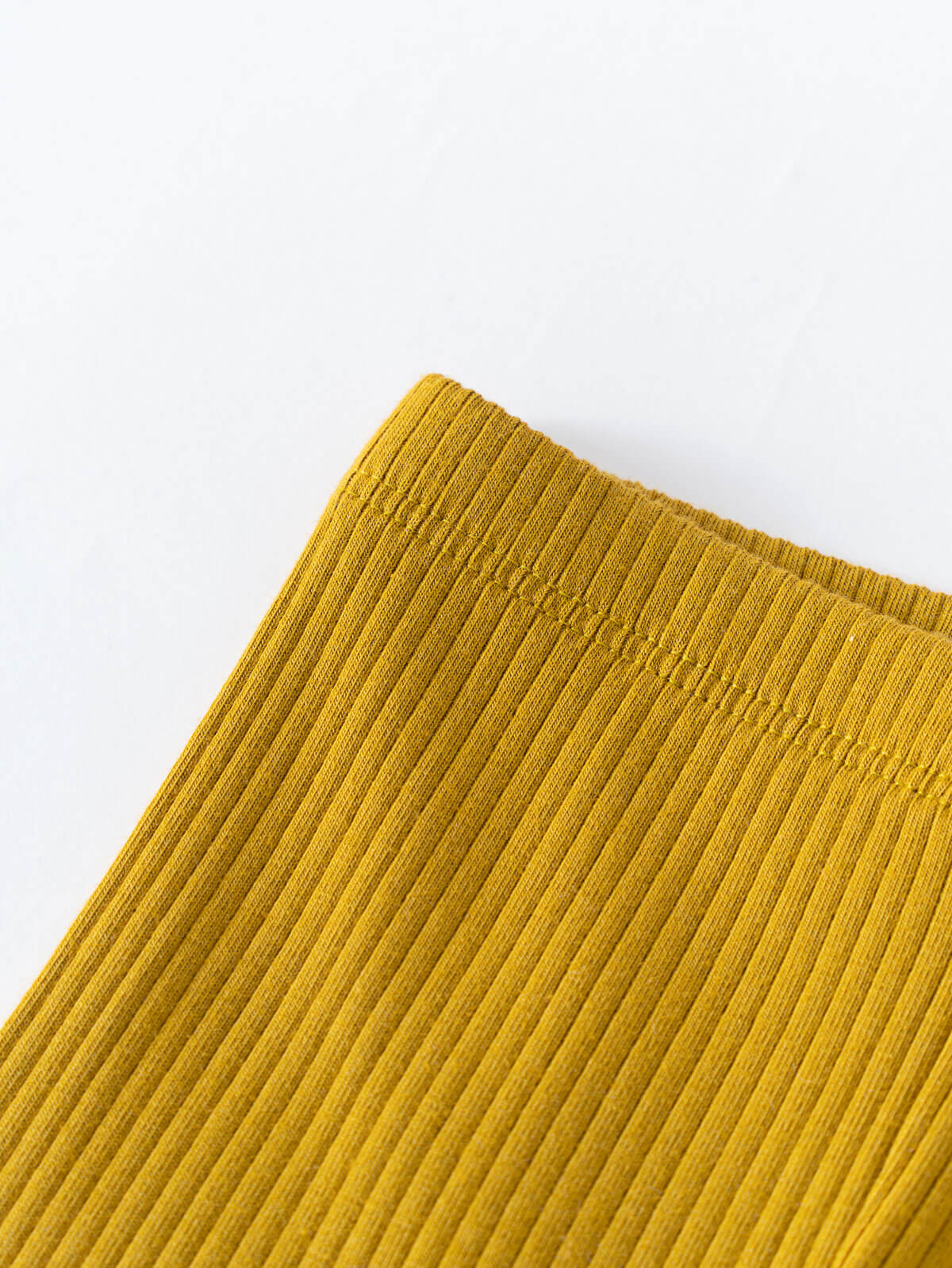 Close-up of mustard yellow ribbed fabric texture on white background Baby Ribbed Leggings - Golden Pear Baby boy