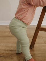 Baby wearing sage green ribbed leggings and floral top near wooden chair Baby Ribbed Leggings - Sage Baby boy