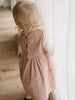 Child wearing a pink corduroy dress standing indoors with a neutral background Baby Corduroy Dress - Blush Baby girl
