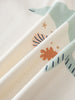 Close-up of folded fabric showing abstract shapes and patterns in cream and sage colors Feature Print Short Sleeve Tee - Dolphin Short Sleeve Tee Shirt - Dolphin Girls