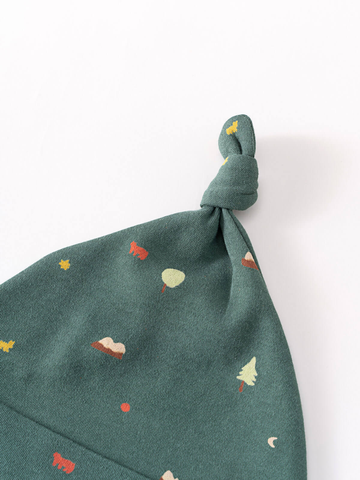 Green fabric baby hat with knotted top featuring small printed motifs Knot Hat - Mountain View Balsam Baby boy