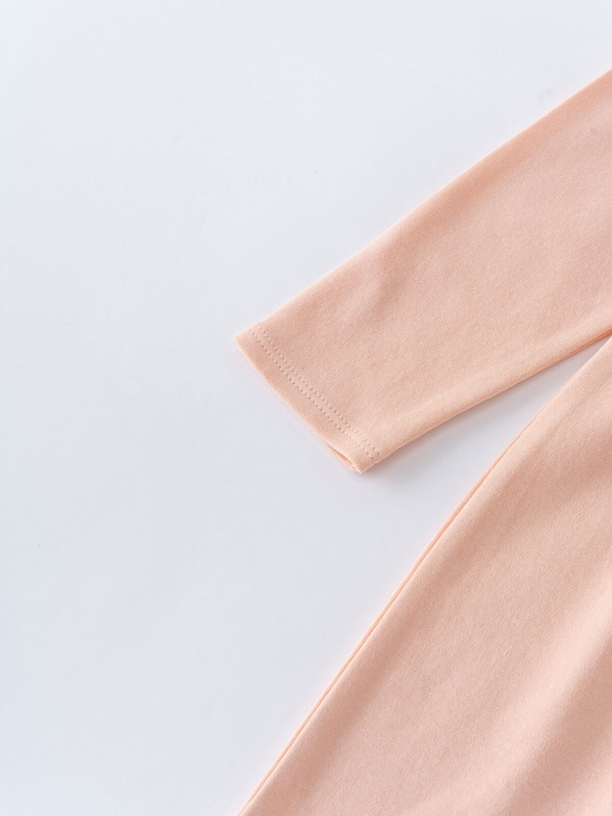 Close-up of peach-colored long sleeve jersey fabric with hemmed cuff detail Long Sleeve Jersey Dress - Mallow Girls