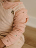 Baby wearing pink patterned long sleeve bodysuit with cream ribbed vest Long Sleeve Bodysuit - Autumn Harvest Rosehip Baby girl