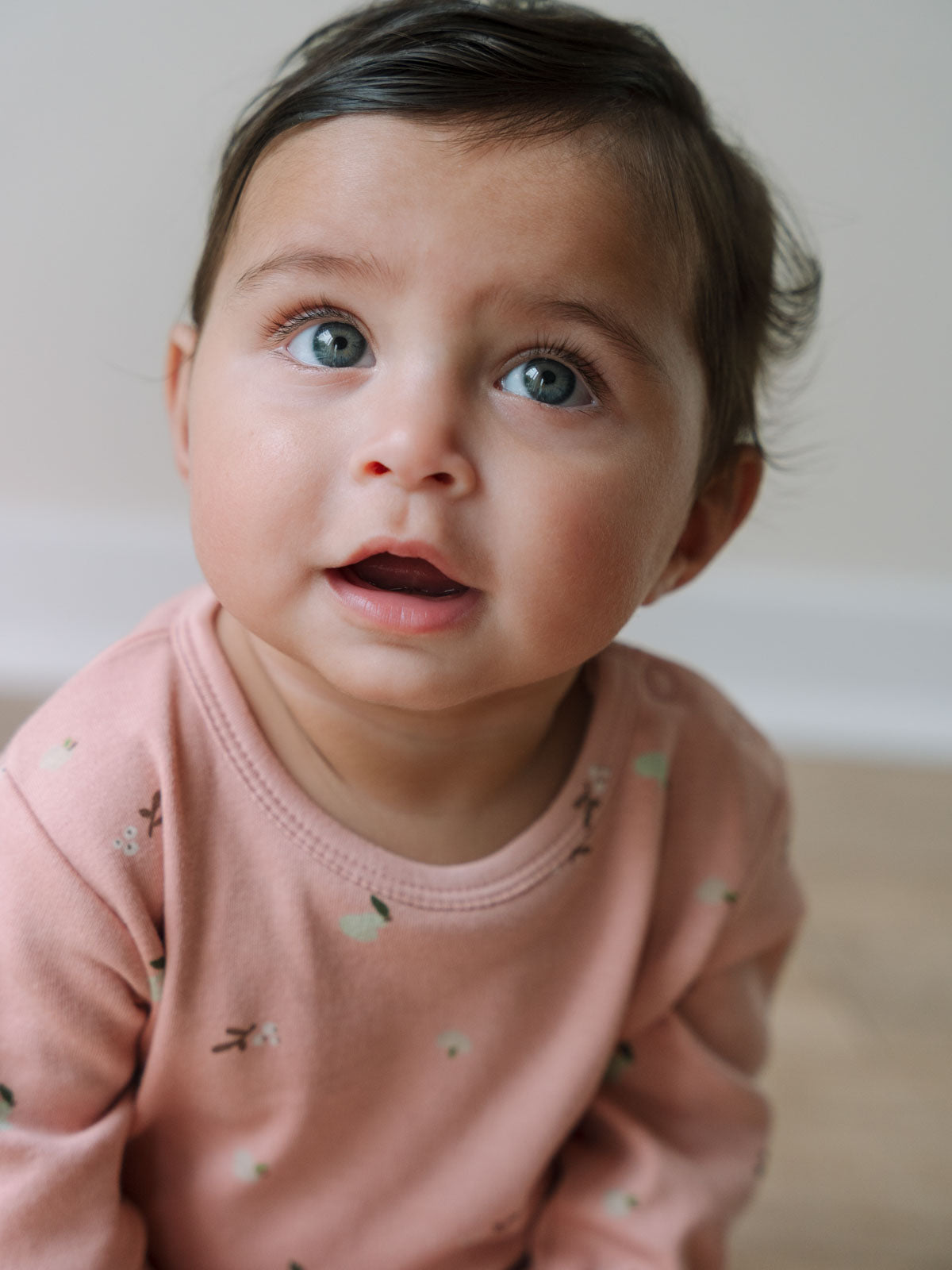 Baby wearing a pink floral patterned long sleeve bodysuit looking upward Long Sleeve Bodysuit - Autumn Harvest Rosehip Baby girl