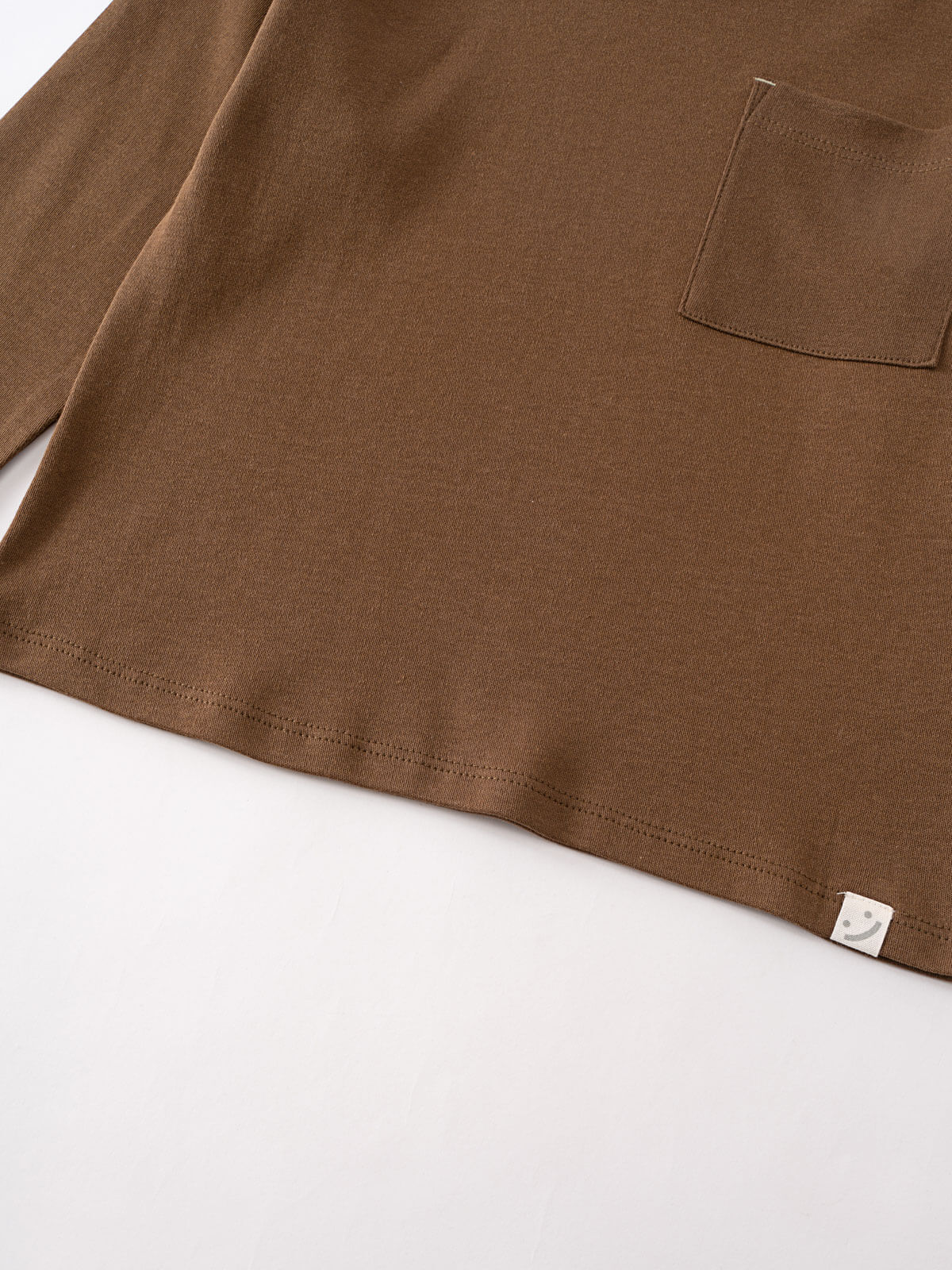 Close-up of brown long sleeve shirt showing chest pocket and hem detail Long Sleeve Tee - Spruce Boys