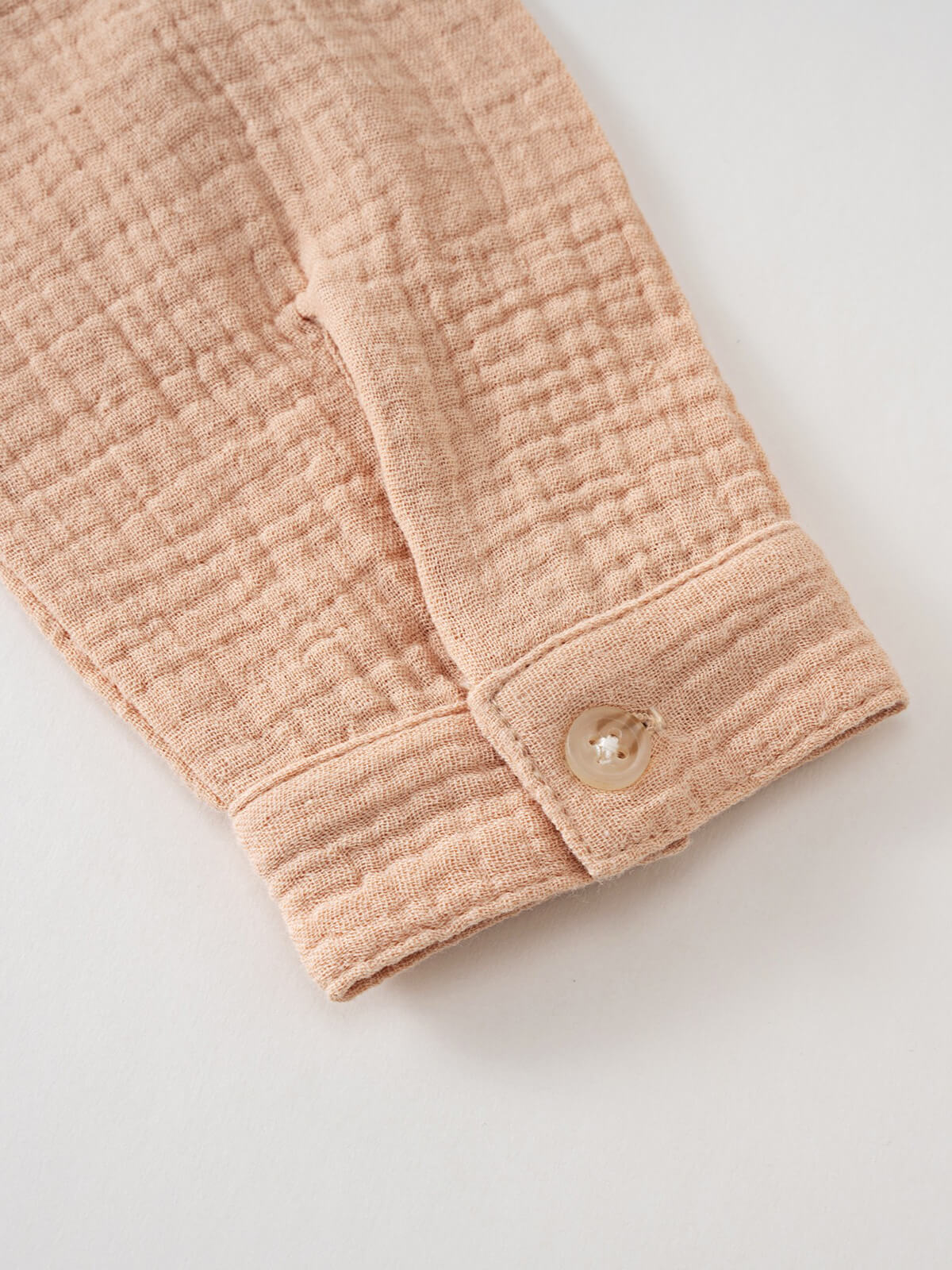 Close-up of a beige textured fabric sleeve cuff with a button fastening Muslin Long Sleeve Shirt - Sand Boys