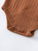 Close-up of rust-colored knit baby bodysuit with snap closures and textured pattern Pointelle Crossover Bodysuit - Russet Baby boy