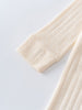 Close-up of a textured beige fabric on a light gray background Pointelle Long Sleeve One Piece - Ecru Baby boy