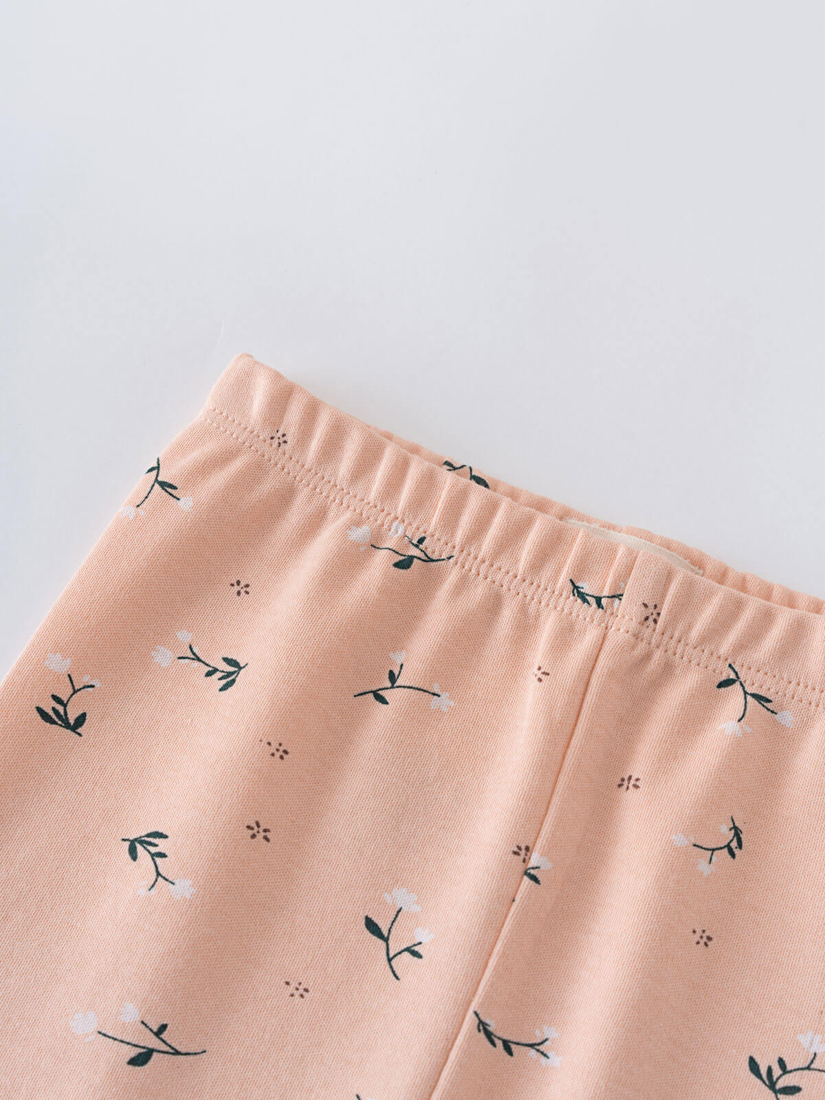 Close-up of peach fabric with small floral and branch print pattern Printed Leggings - Wild Meadow Mallow Girls