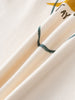 Close-up of white fabric with green and yellow printed design details Printed Long Sleeve Tee - Stay Wild Boys