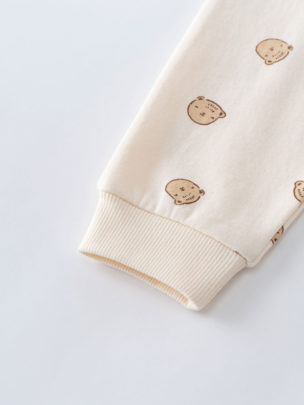 Close-up of cream fabric sleeve cuff with small brown bear print pattern Printed Sweatpants - Cosy Bear Ecru Baby boy