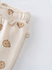 Close-up of cream fabric pants with brown bear print and elastic waistband Printed Sweatpants - Cosy Bear Ecru Baby boy