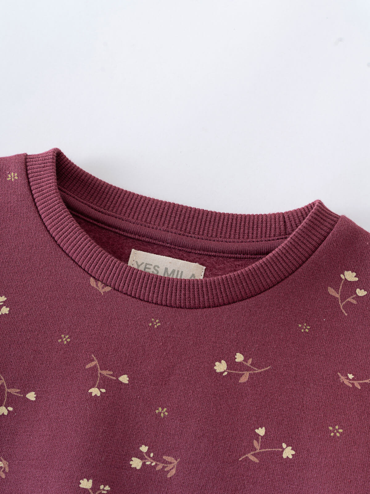 Close-up of a plum-colored sweatshirt with small floral print pattern Printed Sweatshirt - Wild Meadow Plum Jam Girls