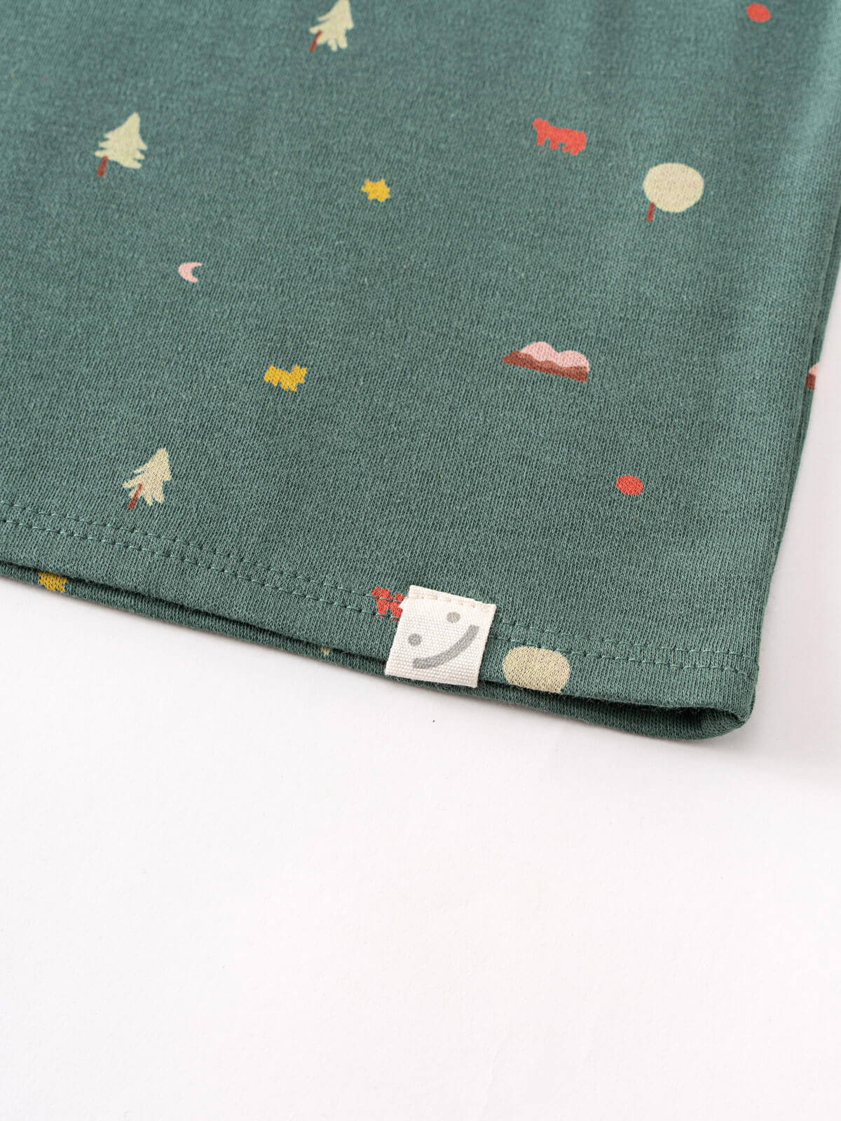 Close-up of teal fabric with small printed trees and shapes pattern Baby Printed Short Sleeve Tee - Mountain View Ecru Baby boy