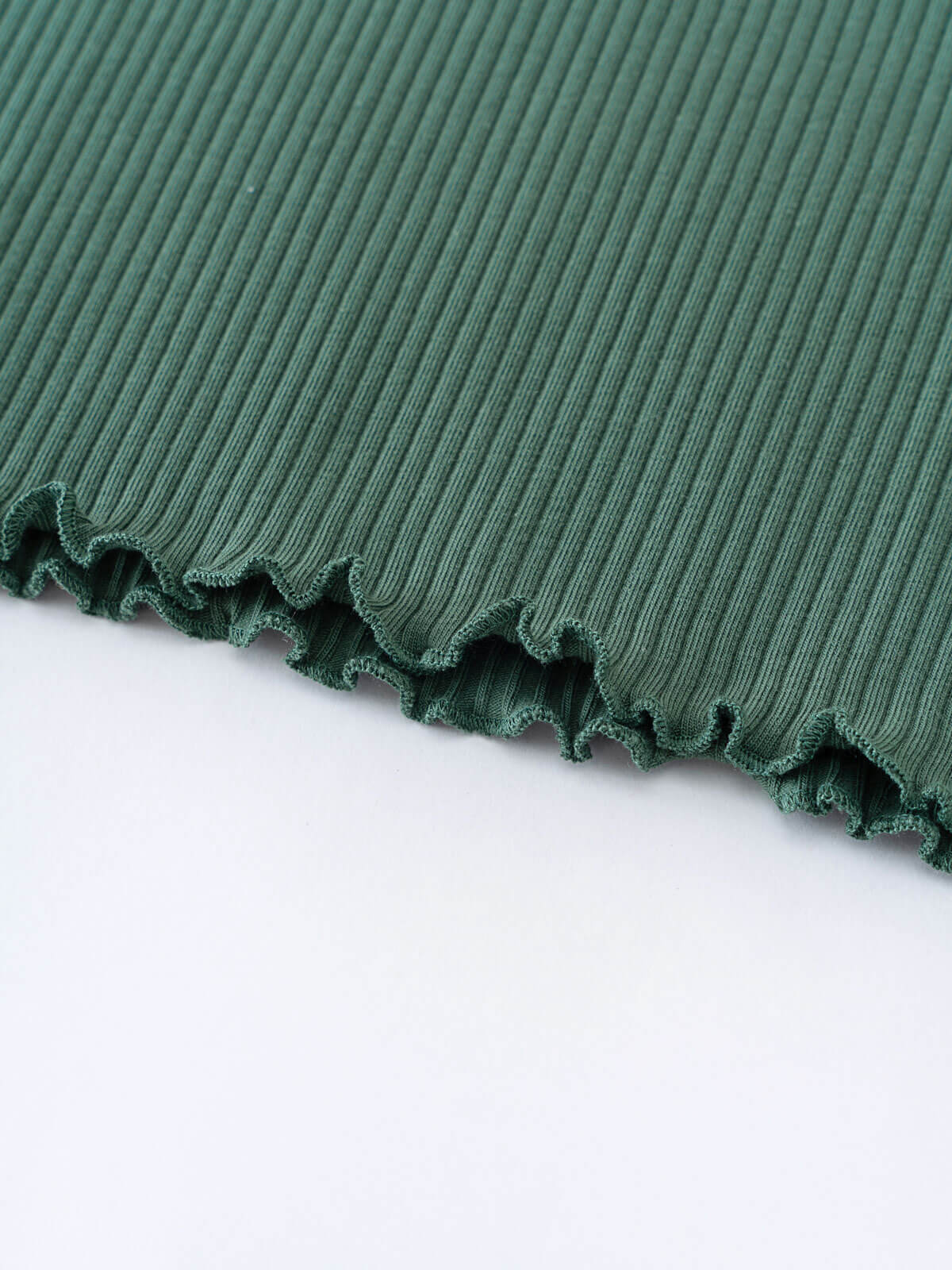 Close-up of dark green ribbed fabric with ruffled lettuce edge trim Ribbed Long Sleeve Tee - Balsam Girls