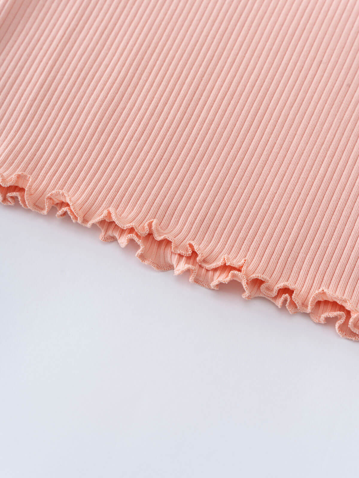 Close-up of pink ribbed fabric with ruffled lettuce edge trim Ribbed Long Sleeve Tee - Mallow Girls