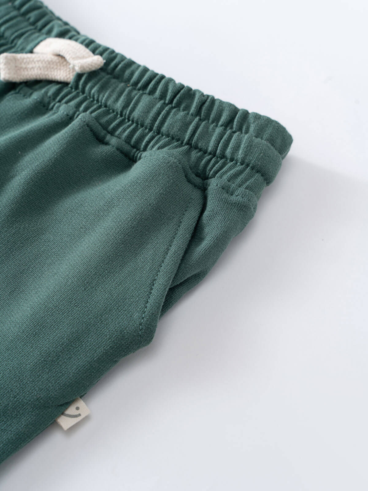 Close-up of green sweatpants showing elastic waistband and cream drawstring Sweatpants - Balsam Boys