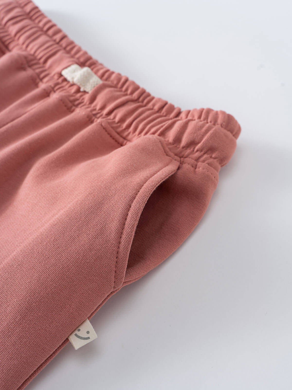 Close-up of pink pants with a brand tag on a white background Sweatpants - Rosehip Girls
