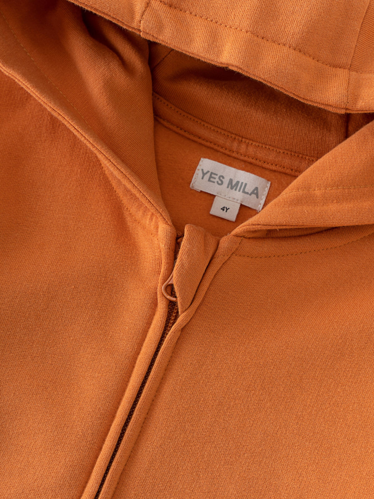 Close-up of an orange zip hoodie showing zipper and label detail Zip Hoodie - Pumpkin Boys