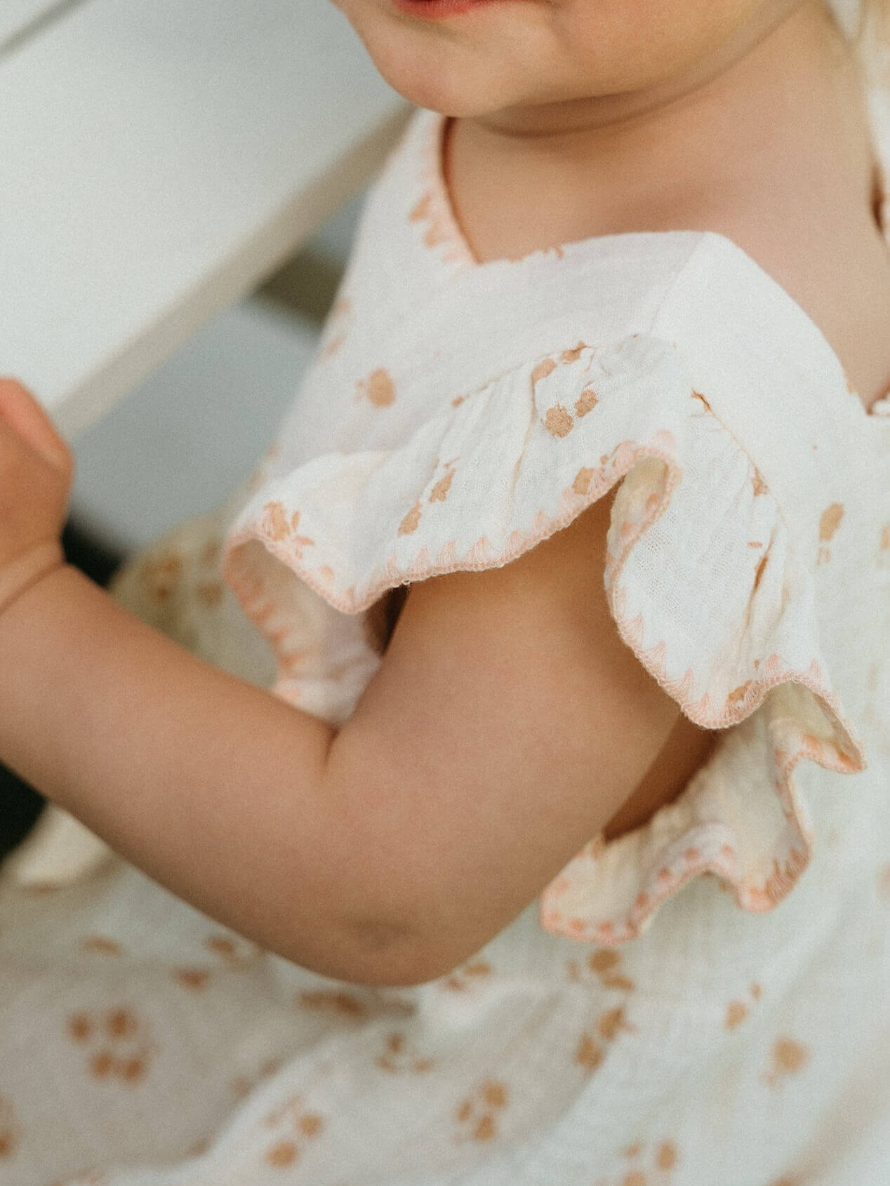 Close-up of a child's arm with a patterned dress