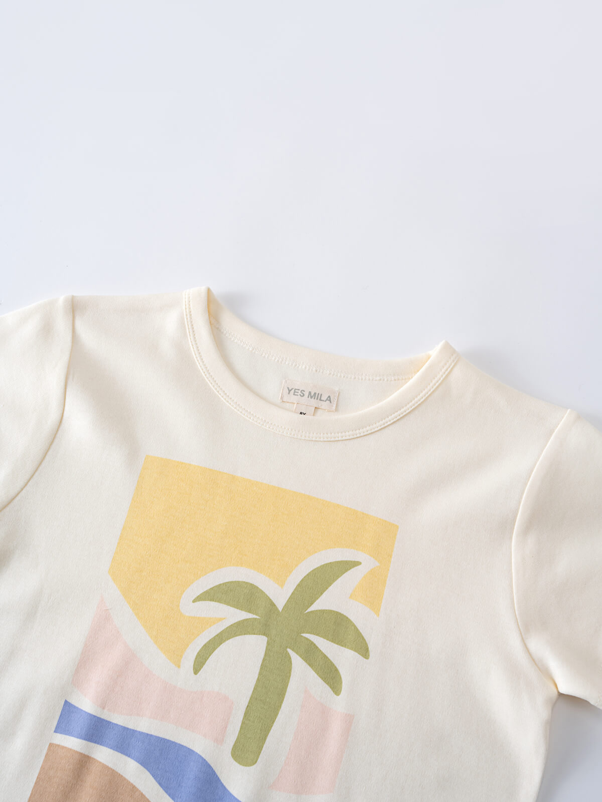 Close-up of a cream-colored t-shirt with a palm tree and geometric design Axel Short Sleeve Tee - Palm Beach Boys