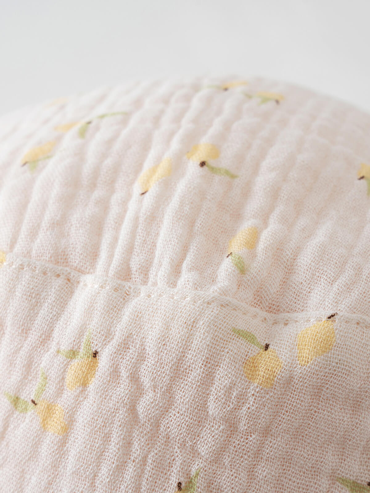 Close-up of a white fabric hat with yellow lemon print pattern Baby Bucket Hat - Lemons Baby girl