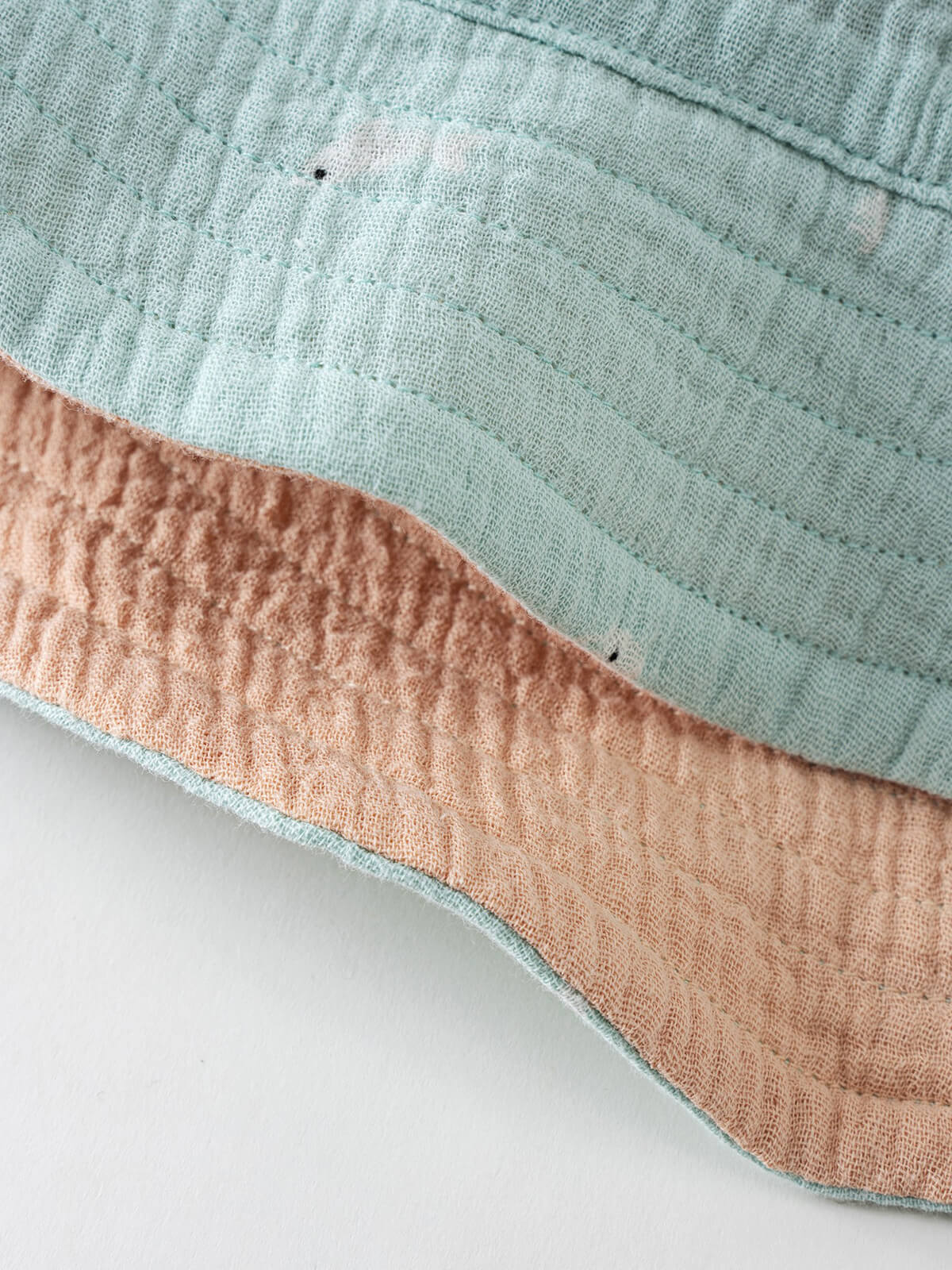 Close-up of mint green and peach textured fabric with contrasting trim Baby Bucket Hat - Sea Friends Baby boy