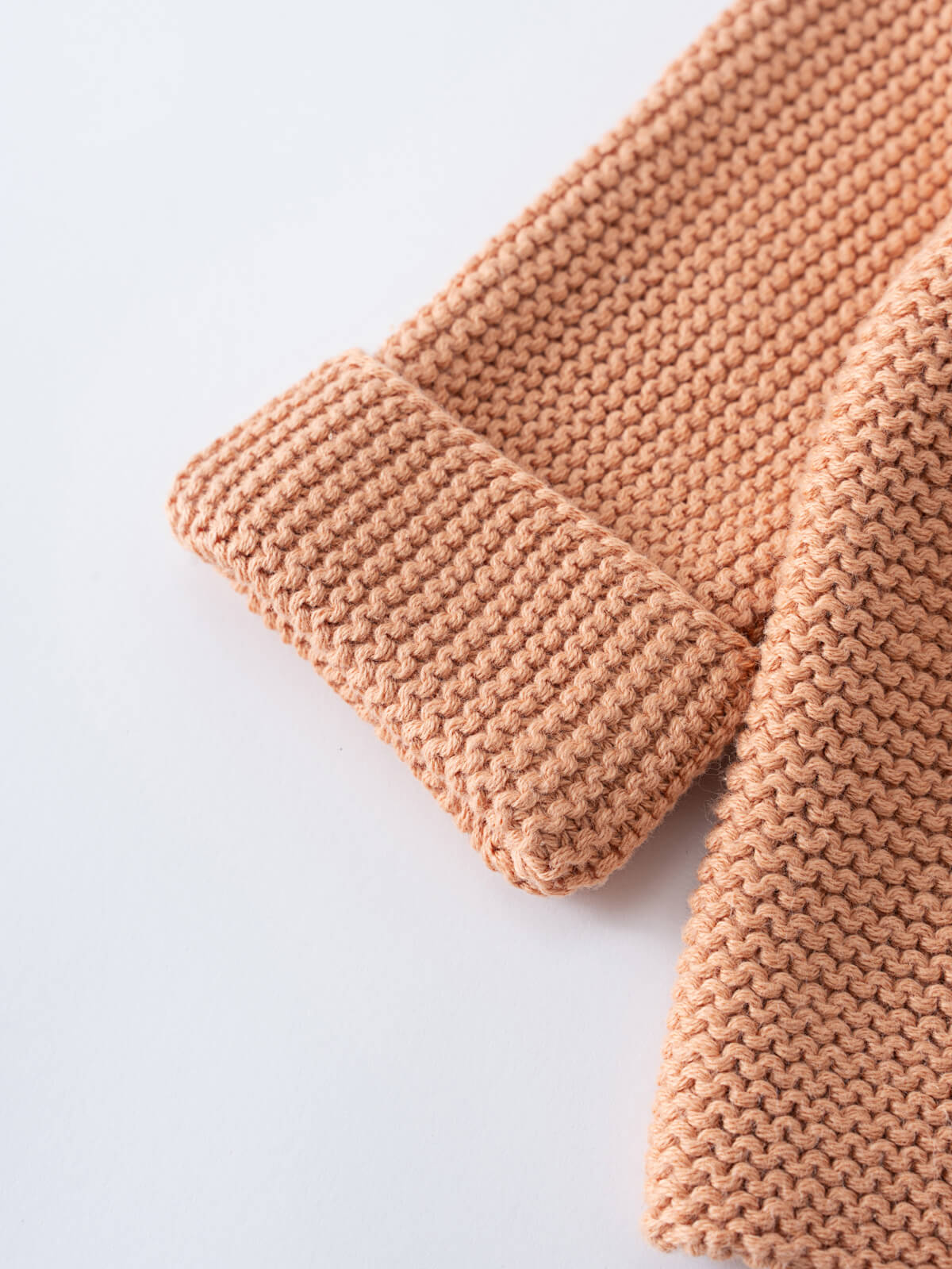 Close-up of a peach-colored knitted cardigan sleeve showing textured stitching Baby Cotton Cardigan - Salted Caramel Baby boy