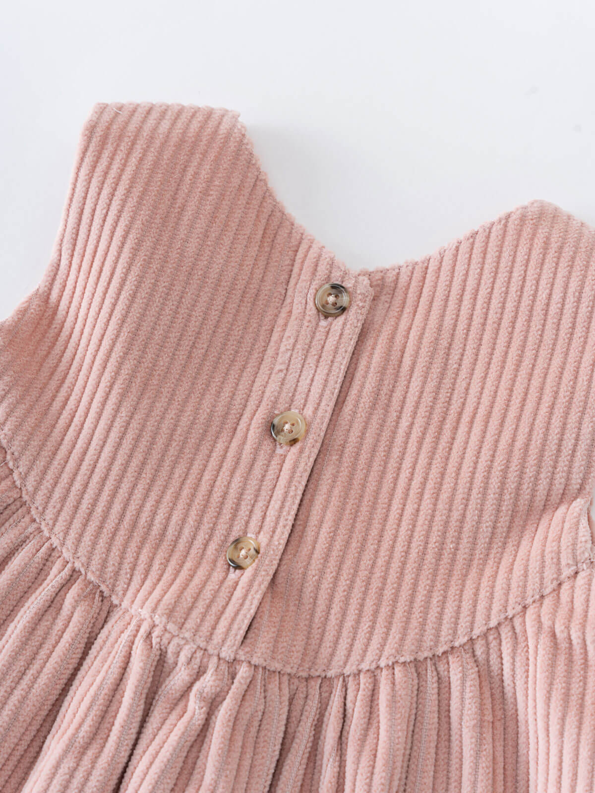 Close-up of a pink corduroy dress with buttons on a white background Baby Corduroy Dress - Blush Baby girl
