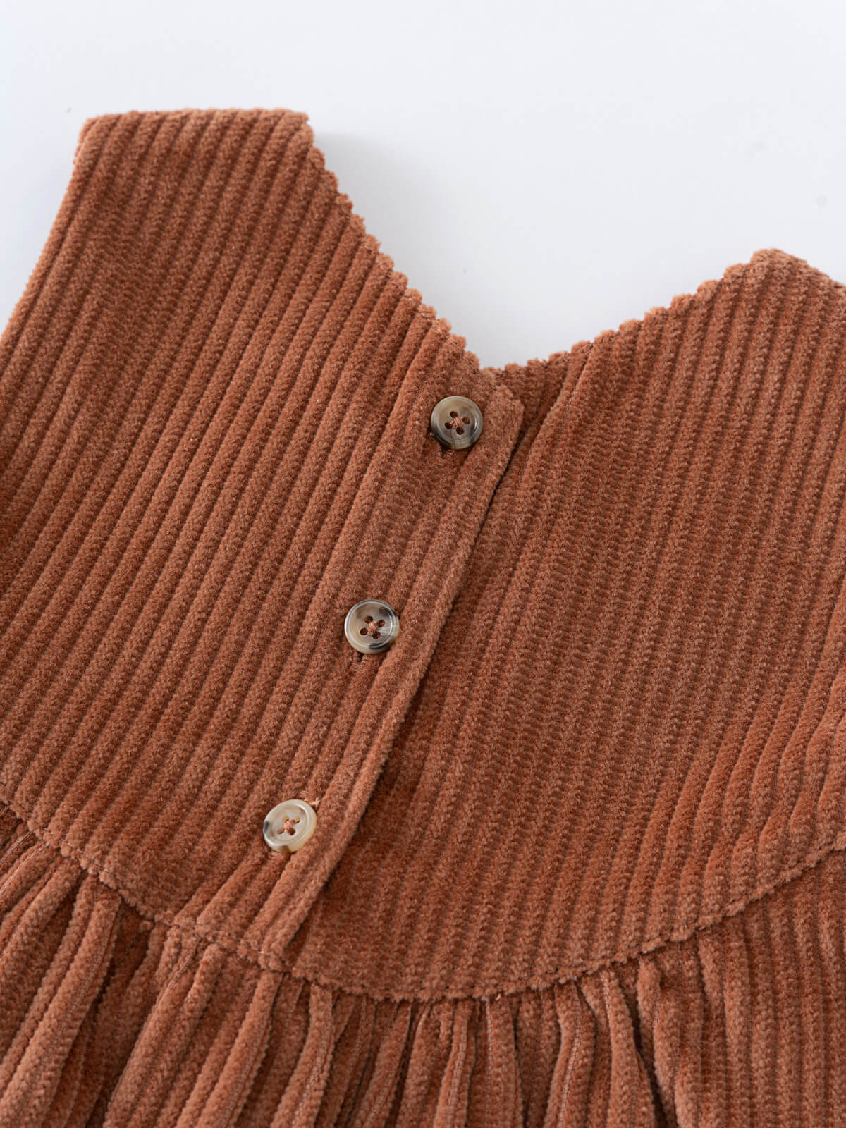 Close-up of a brown ribbed sweater with buttons on a white background Baby Corduroy Dress - Russet Baby girl