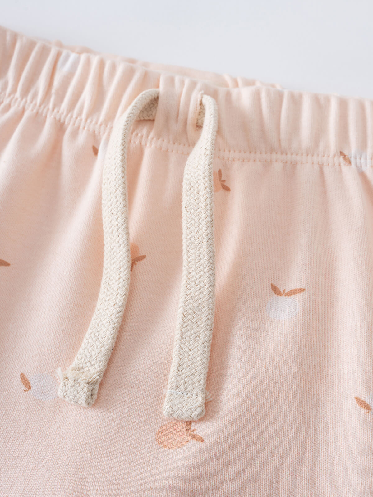 Close-up of pale pink shorts with apple print and cream drawstring waistband Baby Jersey Shorts - Apples Baby girl