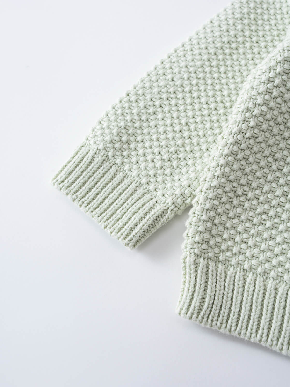 Close-up of a pale green knitted sweater sleeve with ribbed cuffs Baby Knit Jumper - Mint Baby boy