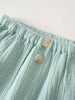 Close-up of mint green textured fabric pants with elastic waistband and buttons Baby Muslin Pants - Calla Green Baby boy