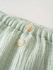 Close-up of light green striped fabric with elastic waistband and two buttons Muslin Shorts - Light Green Stripe Baby boy