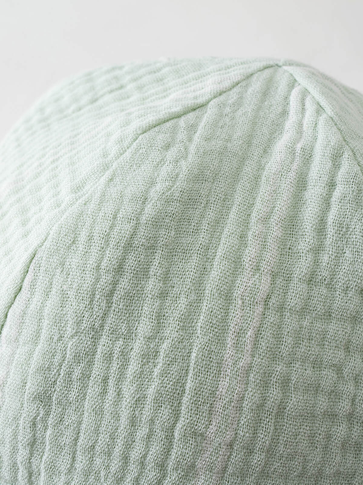 Close-up of a pale green striped fabric hat with ribbed texture Baby Muslin Sun Hat - Green Stripe Baby boy