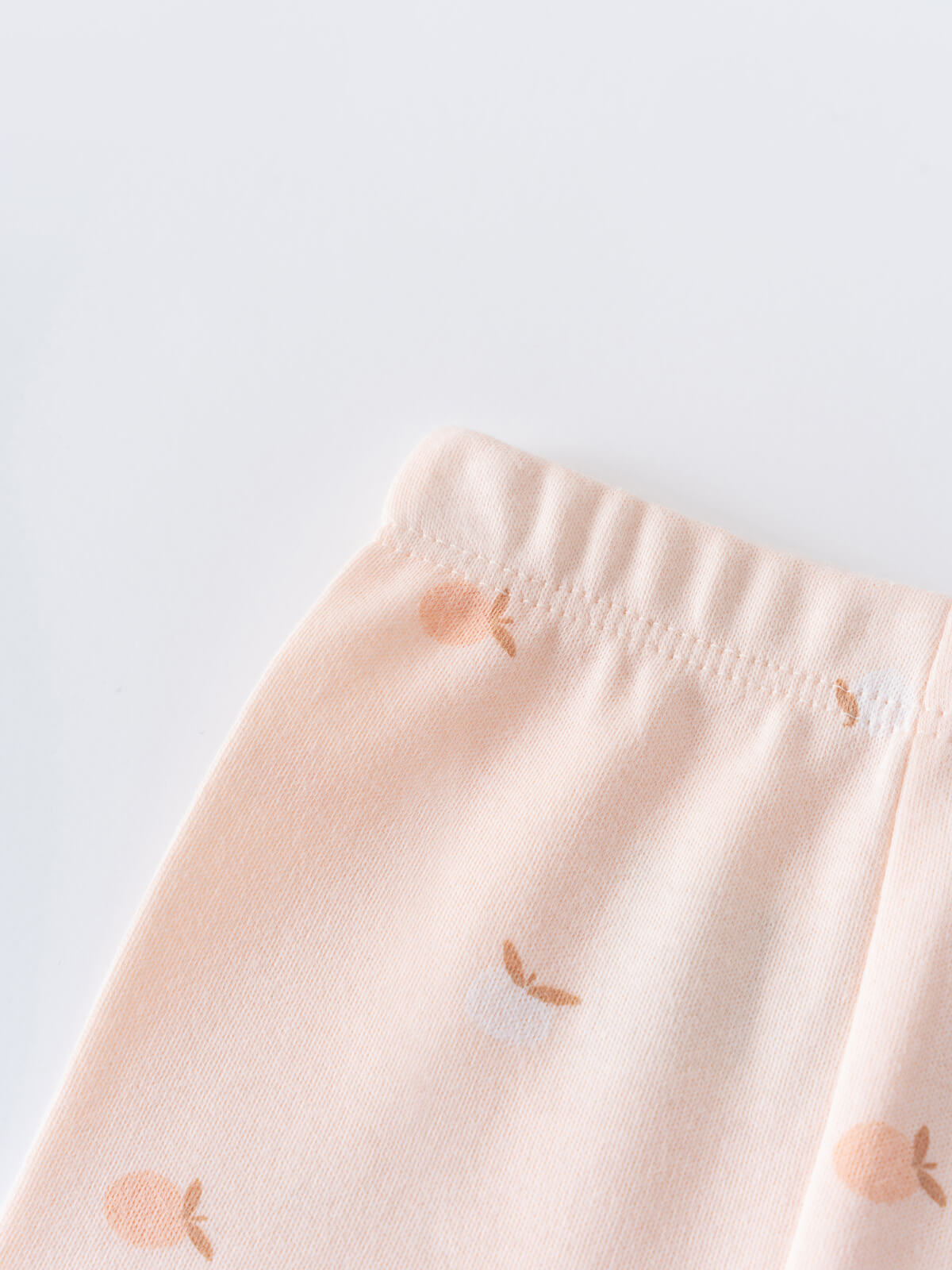 Close-up of pale pink fabric with small apple print pattern Baby Printed Leggings - Apples Baby girl