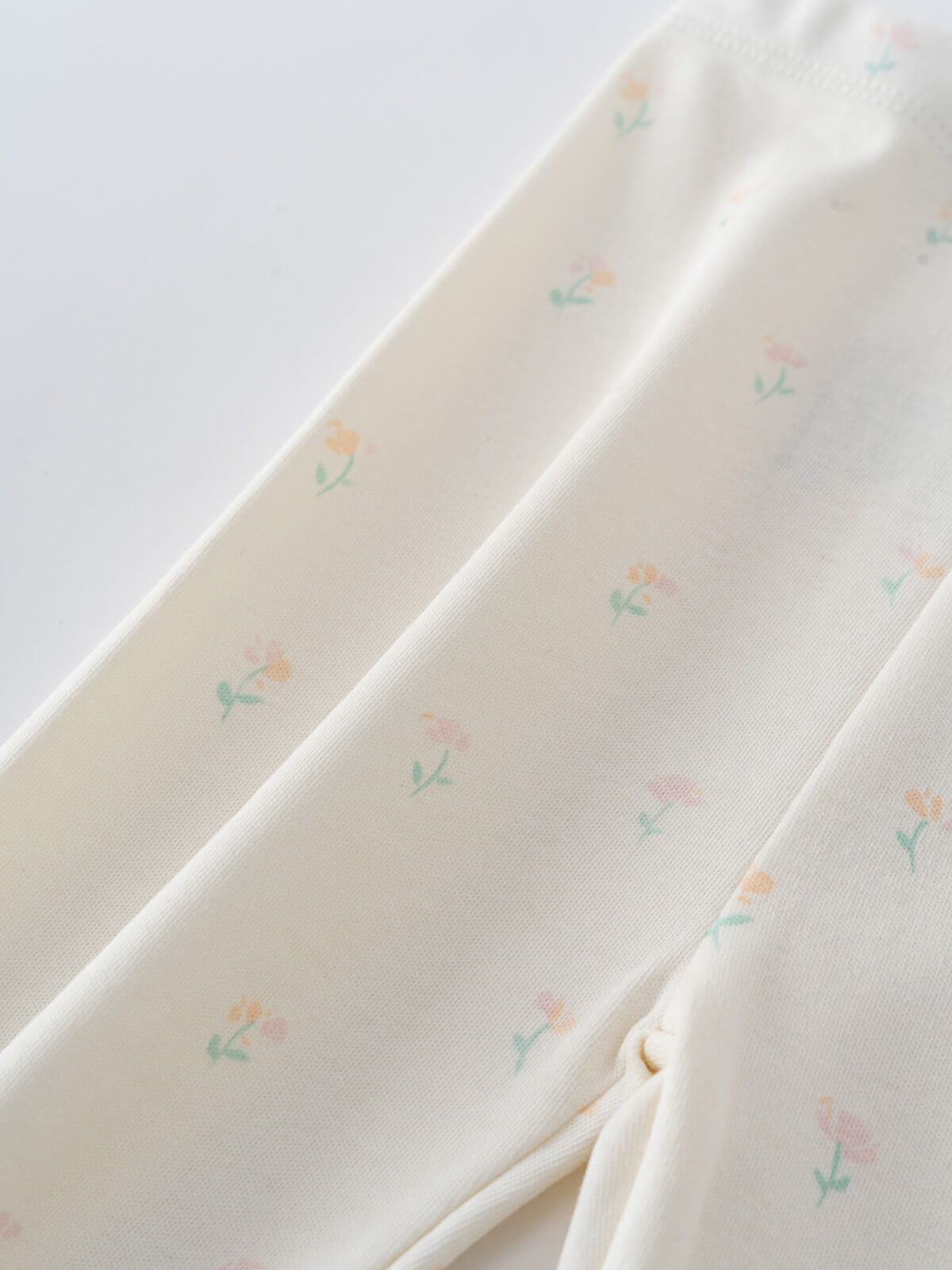 Close-up of cream fabric with small pastel floral print pattern Baby Printed Leggings- Spring Bloom Baby girl
